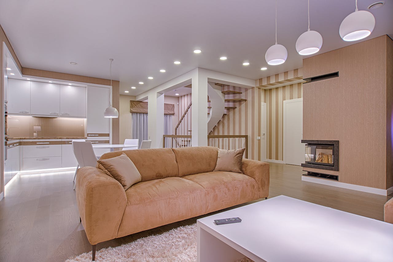 gallery-3 Luxurious living room with modern interior design, featuring beige sofa, fireplace, and open kitchen.