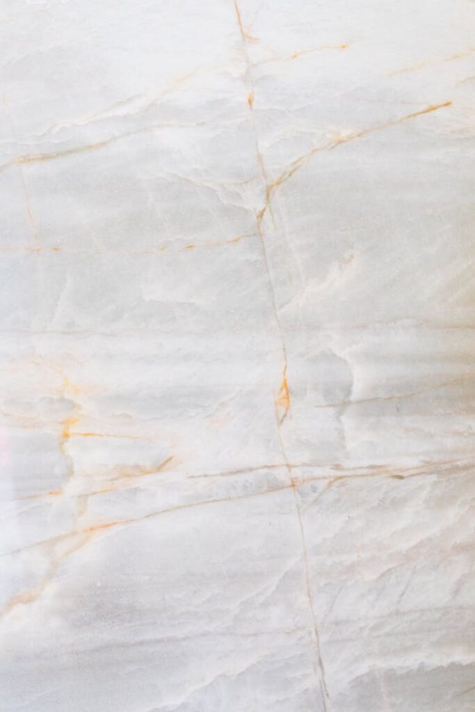 Close-up of a smooth marble surface featuring intricate natural veining and soft tones.