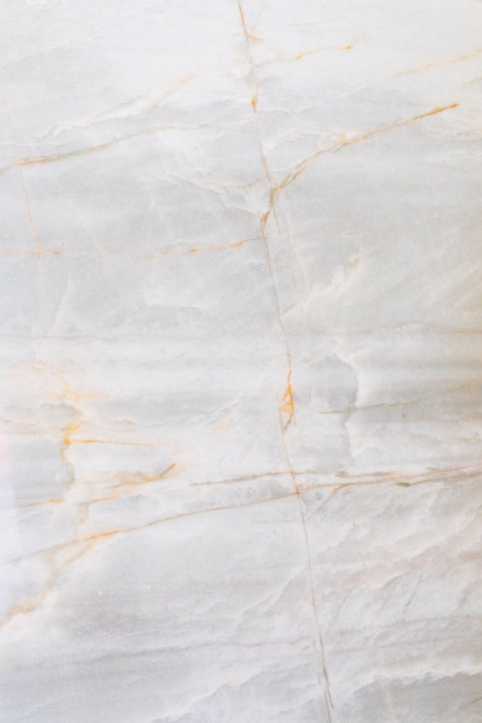 gallery-1 Close-up of a smooth marble surface featuring intricate natural veining and soft tones.