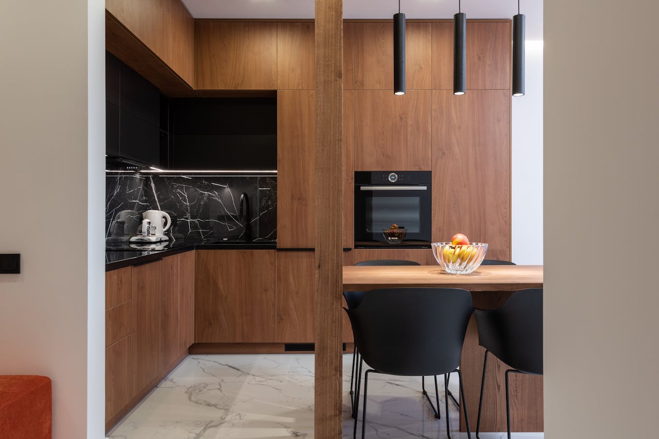 hero-img-01 Sleek kitchen design featuring wooden cabinets, black accents, and modern appliances.